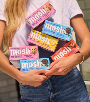 Image of woman carrying 6 boxes of MOSH bars