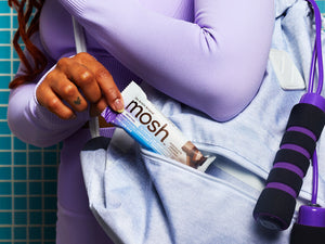 women wearing purple reaching for chocolate crunch mosh bar in her bag